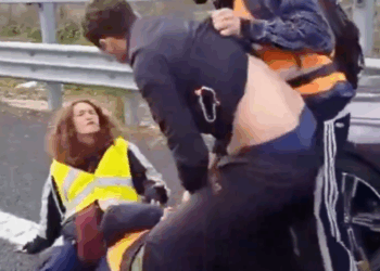 Man verliest geduld en sleept klimaatactivisten hardhandig van de weg om bij zijn zwangere vrouw te komen